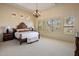 Elegant main bedroom featuring a chandelier, large windows, and a decorative headboard at 34463 N 99Th Way, Scottsdale, AZ 85262