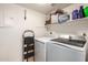 Functional laundry room with modern washer and dryer, ample storage shelves, and easy access electrical panel at 3535 W Monte Cristo Ave # 115, Phoenix, AZ 85053