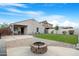 Home exterior featuring a well-maintained lawn and a cozy brick fire pit at 40142 W Coltin Way, Maricopa, AZ 85138