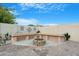 Backyard with a built-in seating area surrounding a brick fire pit feature at 40142 W Coltin Way, Maricopa, AZ 85138