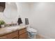 Charming powder room featuring a granite countertop and a modern toilet at 40142 W Coltin Way, Maricopa, AZ 85138