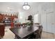 Well-lit dining area with dark wood table set, kitchen view at 40142 W Coltin Way, Maricopa, AZ 85138