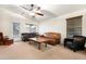 Spacious living room features light carpet, comfortable leather seating, ceiling fan, and a sliding glass door at 40142 W Coltin Way, Maricopa, AZ 85138