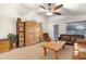 Bright living room features light carpet, ceiling fan, wood furniture, and comfortable leather seating at 40142 W Coltin Way, Maricopa, AZ 85138