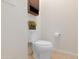 Neutral half-bathroom shows a decorative plant, tile floors, toilet, and overhead cabinet at 40142 W Coltin Way, Maricopa, AZ 85138