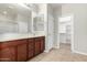 Main bathroom featuring double sinks, tile floors, and walk-in closet access at 41304 W Rio Bravo Dr, Maricopa, AZ 85138