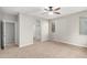 Bright main bedroom with carpet, a ceiling fan, and ensuite bathroom entrance at 41304 W Rio Bravo Dr, Maricopa, AZ 85138