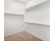 Walk-in closet with white shelving, closet rods, and carpet at 41304 W Rio Bravo Dr, Maricopa, AZ 85138