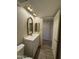 Bathroom vanity with decorative mirror, vanity lights, and laminate flooring at 4200 N Miller Rd # 321, Scottsdale, AZ 85251