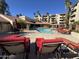 Pool area with lounge chairs, shaded tables, and a pool with views of the building at 4200 N Miller Rd # 321, Scottsdale, AZ 85251