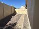 Side yard featuring rock landscaping, a concrete pathway and a wooden gate at 4537 E Shomi St, Phoenix, AZ 85044