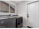 Bright laundry room with gray washer and dryer next to a window and white door at 4537 E Towne Ln, Gilbert, AZ 85234