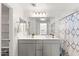 Bright bathroom with double vanity and large mirror over grey cabinets at 5811 W Encinas Ln, Phoenix, AZ 85043