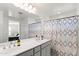 Bright bathroom featuring double sinks, large mirror and a shower curtain at 5811 W Encinas Ln, Phoenix, AZ 85043