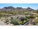 Scenic aerial view of home with beautiful desert mountains, lush landscaping, and tiled roofs at 5858 E Caballo Dr, Paradise Valley, AZ 85253