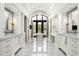 Bathroom with marble floors, dual vanities and a freestanding tub under a window at 5858 E Caballo Dr, Paradise Valley, AZ 85253