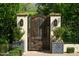 Charming wooden garden gate flanked by brick pillars, lush greenery, and decorative planters, adding a touch of rustic elegance at 5858 E Caballo Dr, Paradise Valley, AZ 85253