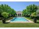 Beautiful pool and fountain view, framed by mature trees and manicured lawn, create a serene backyard retreat at 5858 E Caballo Dr, Paradise Valley, AZ 85253