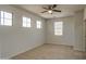 A bright bedroom featuring carpet flooring, neutral walls, and a ceiling fan at 6192 S Claiborne Ave, Gilbert, AZ 85298