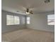 Well-lit bedroom with neutral carpet, a ceiling fan, and multiple windows offering plenty of natural light at 6192 S Claiborne Ave, Gilbert, AZ 85298