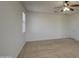 Bright bedroom with carpet, a ceiling fan, and a window, plus a door leading to another room at 6192 S Claiborne Ave, Gilbert, AZ 85298