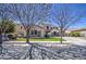 Inviting home with stone details, lush green lawn, and curb appeal enhanced by mature trees at 6192 S Claiborne Ave, Gilbert, AZ 85298