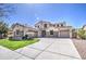 A luxurious two-story home with a three-car garage, stone accents, and a beautifully landscaped front yard at 6192 S Claiborne Ave, Gilbert, AZ 85298