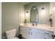 Modern powder room boasts sage green walls, white vanity with stylish lighting and mirror at 6645 N Paint Ln, Casa Grande, AZ 85194