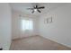 Bedroom with carpet floors, ceiling fan, window with curtains, and two pieces of wall decor at 6645 N Paint Ln, Casa Grande, AZ 85194