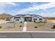 Striking single-story home with white exterior, desert landscaping and solar panels at 6645 N Paint Ln, Casa Grande, AZ 85194