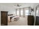 Spacious bedroom with neutral carpet, ceiling fan, and decorative wall trim for added character at 6645 N Paint Ln, Casa Grande, AZ 85194