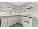 Well-lit kitchen featuring gray cabinets, laminate countertops, stainless steel sink, and gas range at 730 S Country Club Dr # 5, Mesa, AZ 85210