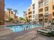 A luxurious community pool features resort-style lounge chairs, ample seating, and beautiful palm trees at 7301 E 3Rd Ave # 101, Scottsdale, AZ 85251