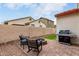 Outdoor patio with a fire pit, seating, and grill against a privacy wall, ideal for gatherings at 7421 W Montgomery Rd, Peoria, AZ 85383