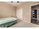 Neutral-toned bedroom featuring a simple bed frame and an adjoining room through a doorway at 7421 W Montgomery Rd, Peoria, AZ 85383