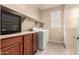 Well-equipped laundry room with a washer, dryer, countertop space, wine fridge and storage cabinets at 7421 W Montgomery Rd, Peoria, AZ 85383