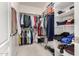 Organized walk-in closet featuring hanging clothes and shelving for shoes and accessories at 7421 W Montgomery Rd, Peoria, AZ 85383