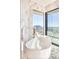 Bright bathroom features a soaking tub with a view of the city skyline, and a chair to relax in at 7701 N Silvercrest Way, Paradise Valley, AZ 85253