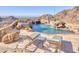 Luxurious custom pool featuring stone accents and a waterfall, surrounded by lounge chairs and beautiful landscaping at 7701 N Silvercrest Way, Paradise Valley, AZ 85253