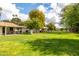 Well-manicured backyard with lush lawn, mature trees, and patio views, ideal for outdoor enjoyment at 9809 W Pleasant Valley Rd, Sun City, AZ 85351