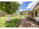 Inviting backyard with a covered patio and a lush, well-maintained lawn and mature trees at 9809 W Pleasant Valley Rd, Sun City, AZ 85351