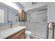 Bright bathroom features a marble countertop vanity, a shower with glass doors and a storage cabinet at 9809 W Pleasant Valley Rd, Sun City, AZ 85351