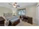 Bedroom featuring neutral carpet, ceiling fan, a large dresser and an adjacent desk area at 9809 W Pleasant Valley Rd, Sun City, AZ 85351