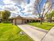 Charming single-story home with brick accents, a well-manicured lawn, and a welcoming driveway at 9809 W Pleasant Valley Rd, Sun City, AZ 85351