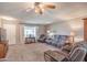 Comfortable living room featuring a plush reclining sofa, ceiling fan and neutral carpet at 9809 W Pleasant Valley Rd, Sun City, AZ 85351