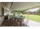 Relaxing covered patio with a table, chairs, and a view of the landscaped backyard at 9809 W Pleasant Valley Rd, Sun City, AZ 85351