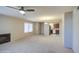 Bright living room with neutral carpet, ceiling fan, and view into adjacent kitchen at 10115 E Mountain View Rd # 1005, Scottsdale, AZ 85258