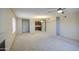 Spacious living room with neutral carpet, ceiling fan, and view into adjacent kitchen at 10115 E Mountain View Rd # 1005, Scottsdale, AZ 85258