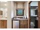 Stylish bar area with mini fridge, coffee maker, and wooden cabinetry near walk-in closet at 10561 E Addy Way, Scottsdale, AZ 85262