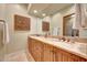 Bathroom showcasing a double sink vanity, marble countertop, and decorative mirror at 10561 E Addy Way, Scottsdale, AZ 85262